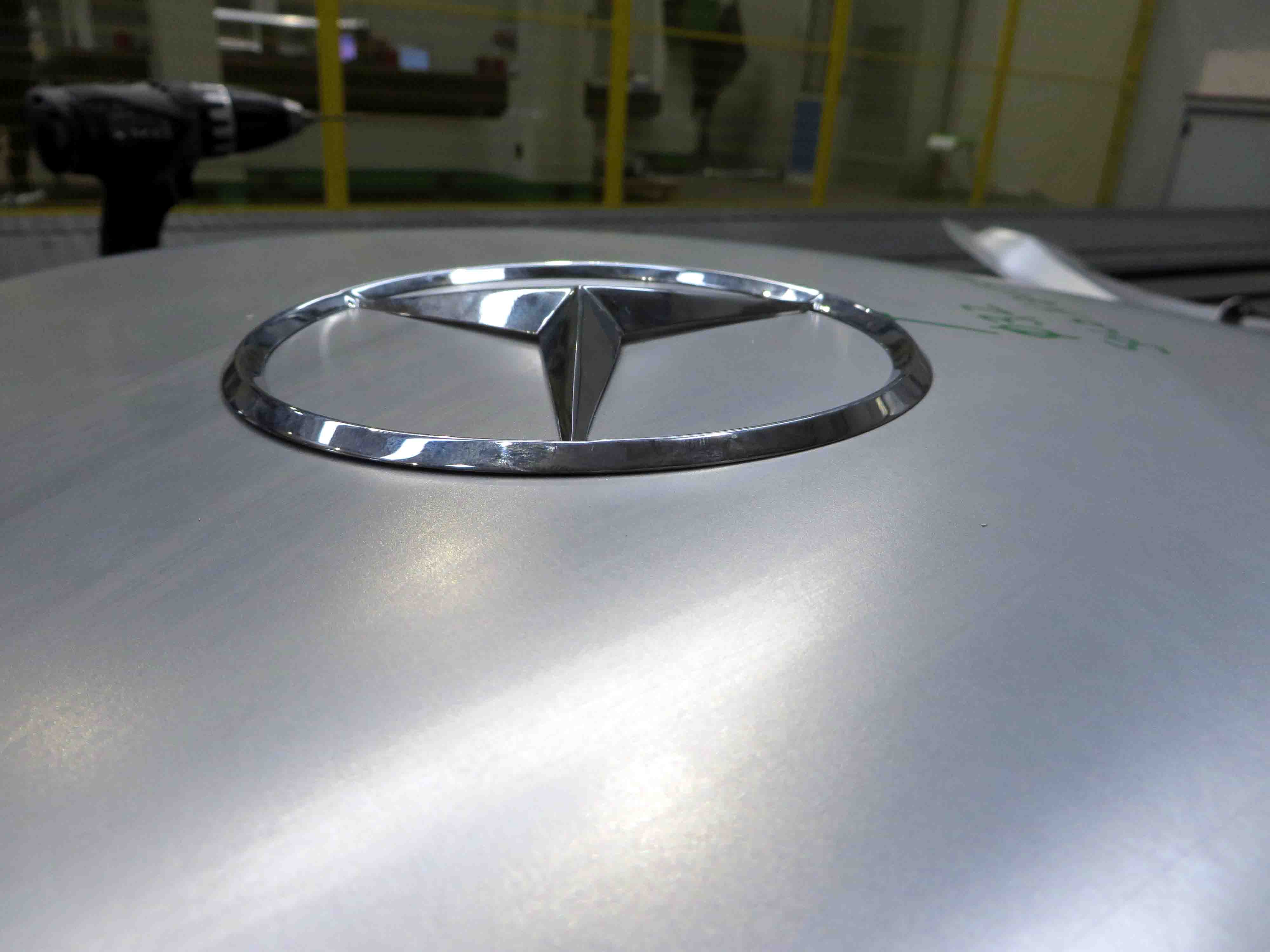 Mercedes-Benz Original-Ersatzteile für den 300 SL „Gullwing“ (W 198, 1954 bis 1957). Nachfertigung von Karosserie-Blechteilen gemäß den hohen Werksstandards der Daimler AG. Das Foto zeigt die Prüfung der Heckdeckel-Wölbung: Der Mercedes-Stern liegt flächenbündig auf. Mercedes-Benz genuine replacement parts for the 300 SL “Gullwing” (W 198, 1954 to 1957). Reproduction of metal body parts in accordance with the high factory standards of Daimler AG. The photo shows the inspection of the curved section of the boot: the Mercedes star is flush with the surface.